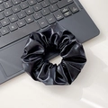 Glossy black faux leather scrunchie with a sleek metallic finish and pleated texture - Hair Tie / Black