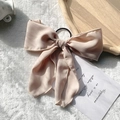Elegant nude pink chiffon bow hair scrunchie with long ribbons on a white faux fur rug - Beige