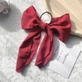 Elegant wine red chiffon bow hair tie with long ribbons on a soft plush background - Burgundy