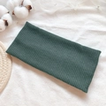 Vintage dark green ribbed knit headband accessory on a clean minimalist fabric background - Green