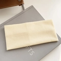 Elastic knitted wide headband in beige with ribbed texture on a decorative book - New Beige