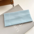 Vintage light blue ribbed knit headband with soft elastic texture on grey book background - New Blue