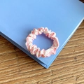 Pink and white striped fabric scrunchie with classic pleated design on a blue book - Small Size / Pink