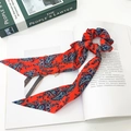 Chouchou en satin rouge à motif cachemire avec rubans longs sur un livre décoratif - Bohème Rouge