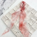 Chouchou tie-dye orange et blanc avec longs rubans sur une surface en pierre - Tie-Dye Rose