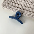 Primer plano de una pinza de pelo mini azul marino brillante con un diseño de nudo cruzado - Azul marino