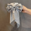 Eleganter grauer Satin-Haarclip mit großer Schleife und langen Bändern auf Karte - Silbergrau
