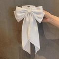 Eleganter weißer Satin-Haarclip mit großer Schleife und langen Bändern auf Karte - Reinweiß