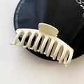 Large matte cream dragon bone hair claw clip for thick hair styling on a black plate - White