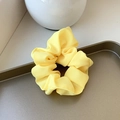 Chiffon scrunchie in lemon yellow with elegant pleated texture on a golden tray - Small / Bright Yellow
