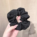 French vintage black pleated scrunchie with wrinkled fabric texture held in hand - Black