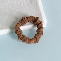 Chouchou en velours côtelé marron avec texture ondulée sur fond de papier froissé - Gris foncé