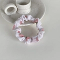 Détail d'un chouchou en tissu blanc avec de mignons motifs de pêches roses - Pêche