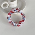 Gros plan du chouchou en tissu à motif de fruits sur un plat en céramique blanche - Pastèque
