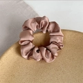 Chouchou élégant en satin champagne avec texture plissée soyeuse sur un plateau en céramique - Rose Poudré