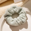 Chouchou en peluche vert menthe doux sur assiette blanche avec pull en maille beige - Vert clair