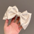 Large cream satin bow hair clip featuring a smooth silk texture and elegant princess style - Off-White