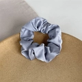 Elegant Morandi blue satin scrunchie with silk texture on minimalist cork stand - Blue Gray