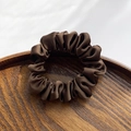 Minimalist dark brown satin scrunchie with silky finish on a wooden display tray - Coffee