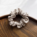 Silky satin scrunchie in champagne beige featuring a minimalist knotted fold design - Champagne