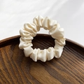 Elegant cream-colored silky satin hair scrunchie displayed on a premium wooden tray - Off White