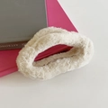 Plush cream white faux fur scrunchie hair tie placed on minimalist books - Beige
