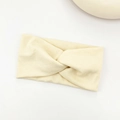 Close-up of cream ribbed knit headband featuring a classic central knotted design - Apricot
