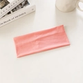Elastic knitted pink headband for sports and yoga shown in a cozy lifestyle setting - Pink