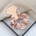 Elegant champagne pink satin scrunchie presented on a diamond shaped display card - Champagne Pink