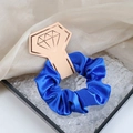 Royal blue satin scrunchie with silky texture on a gold diamond-shaped display card - Sapphire Blue