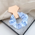 Sky blue satin scrunchie displayed on a rose gold diamond-shaped card holder - Sky Blue