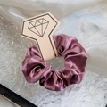 Dusty rose satin scrunchie on a diamond card display with silk fabric background - Brick Red