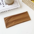Bandeau en tricot marron foncé à haute élasticité sur un bureau blanc minimaliste - Couleur caramel