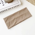 Bandeau élastique en maille kaki plié sur une table blanche au style minimaliste - Café Clair