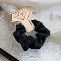 Glossy black satin hair scrunchie on a champagne gold diamond-shaped display card - Black