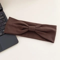 Deep brown elastic yoga headband with twist knot design on a minimalist desk surface - Coffee