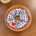 Blue plaid scrunchie with cherry print and red button accent in a woven tray - Blue Plaid