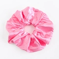 Détail d'un chouchou en satin rose avec strass brillants pour coiffures élégantes - Rose vif