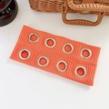 Bright orange ribbed knit headband with silver metal grommets in a stylish punk rock design - Orange