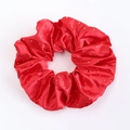Détail d'un chouchou en satin rouge avec strass brillants et texture soie élastique - Rouge