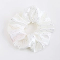 Détail d'un chouchou en satin blanc avec strass étincelants et texture soyeuse - Blanc pur