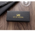 Primer plano de caja de regalo negra para reloj con logo dorado sobre madera - Caja Larga Desnuda
