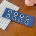 Blue ribbed knit headband featuring eight silver metal eyelets on a wooden table surface - Royal Blue