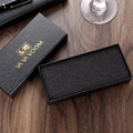 Caja de reloj negra con textura de cocodrilo y logo dorado sobre fondo de escritorio de madera - Juego Estándar de Caja Negra Rectangular Con Relieve