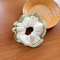 Scrunchie in pizzo e quadretti verdi con design a strati su sfondo in legno rustico - Patchwork in Pizzo a Quadri Verde