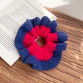 Handmade knitted scrunchie with red and blue contrast stitching on a wooden table - Red and Navy Blue