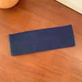 Navy blue ribbed knit elastic yoga headband on a minimalist wooden background - Navy Blue