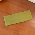 Olive green ribbed knit elastic yoga headband on a rustic wooden background - Grass Green