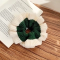 Knitted scrunchie in dark green and beige color block on a vintage book - Green + Cream White