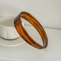 Detailed macro view of an amber tortoiseshell acetate wide headband resting on a ceramic cup - Dark Brown Stripes